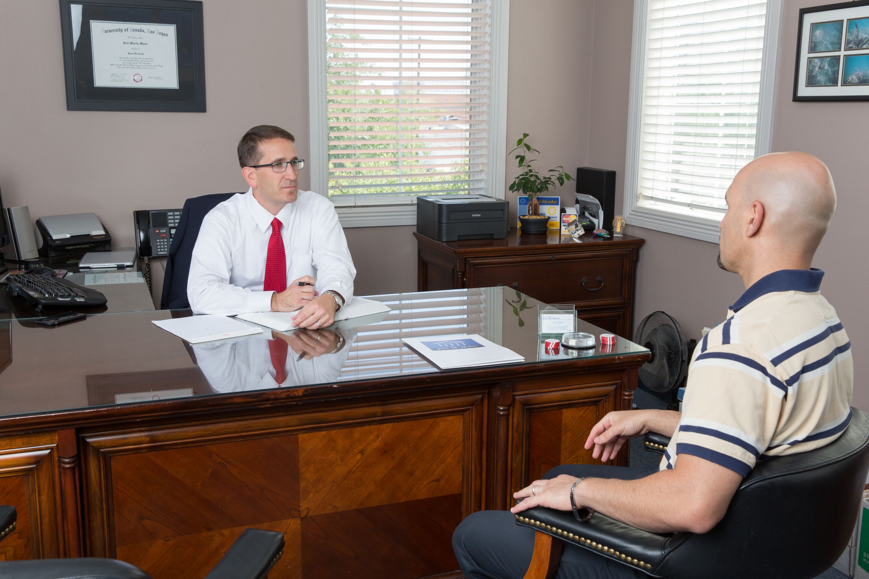 Joel Mann visiting with client in his office.